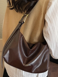Sac à bandoulière en cuir souple marron foncé avec détails dorés et texte gaufré