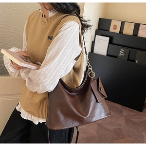 Dettaglio della borsa tote in ecopelle marrone scuro con trama vintage e mini borsellino