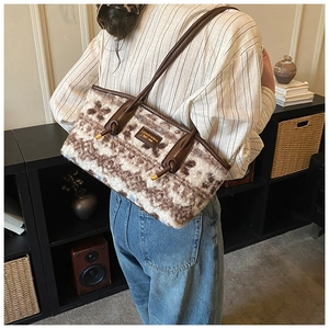 Detail of plush shoulder bag with brown and white mottled pattern and metal logo
