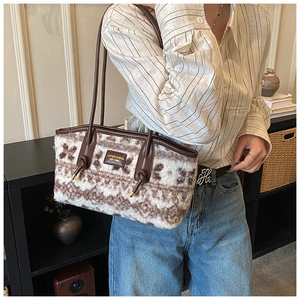 Close-up of fluffy faux shearling tote bag with geometric pattern and brown leather handle