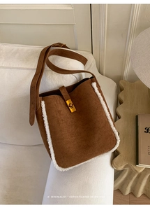 Detail der Retro Wildleder-Eimertasche in Braun mit weißem Pelzbesatz und goldener Schließe