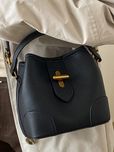 Fashionable black lychee leather bucket bag with gold turn-lock and top handle