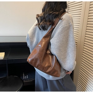 Detail of vintage brown suede tote bag with ruched design and soft matte leather texture