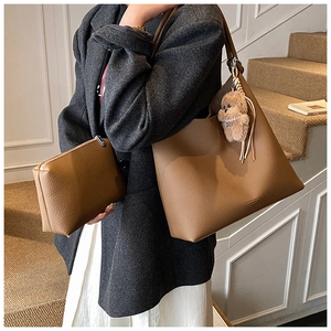 Ensemble de sacs cabas en cuir marron avec pochette et breloque ours sur un escalier