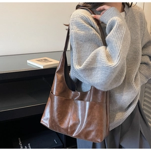 Close-up of brown suede tote bag featuring a front pocket and vintage matte texture