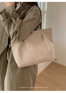 Detail view of large minimalist cream canvas tote bag with magnetic snap and leather strap