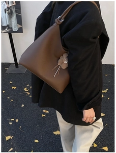 Détail du sac cabas en cuir grainé marron foncé orné d'un joli pendentif en peluche