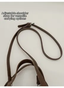 Detailed close-up of brown litchi pattern leather adjustable strap with silver metal buckle