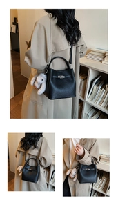 Détail du sac seau en cuir litchi noir avec boucle argentée et charm lapin mignon