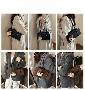 Chic retro baguette bag with leather texture, dual straps and plush bear charm detail