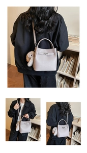 Détails du sac seau en cuir gris avec fermoir rotatif argenté et breloque lapin doux