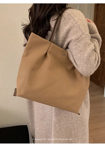 Minimalist large khaki tote bag styled by a model with sophisticated retro design