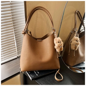 Sac bandoulière en cuir grainé marron avec breloque d'ours en peluche et détails de texture