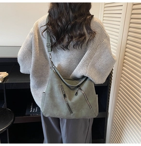 Détail du sac hobo vert sauge avec fermetures éclair diagonales et large bandoulière