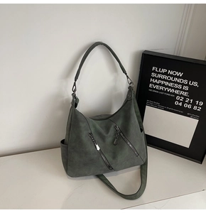 Détail d'un sac cabas mat gris-vert foncé avec fermetures éclair et poches latérales