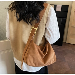 Braune Hobo-Tasche aus Wildleder mit verstellbarer Gold-Schnalle an einem Model getragen