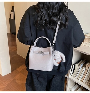Détail du sac seau en cuir grainé gris avec boucle argentée et breloque lapin en peluche