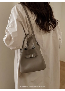 Detail of taupe lychee leather bucket bag showing fine grain texture and metal buckle
