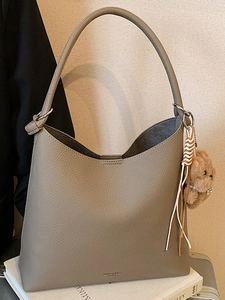 Sac fourre-tout en cuir gris taupe Morandi avec breloque ours et pompon sur livres