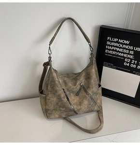 Détail d'un sac cabas vintage kaki avec fermetures éclair métalliques et texture en cuir