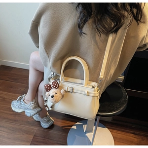 Sac à main chic en cuir PU blanc crème avec breloque ours en peluche en situation réelle