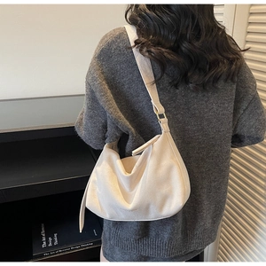 Detail der minimalistischen creme Hobo-Tasche aus Wildleder mit verstellbarer goldener Schnalle