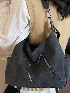 Sac cabas vintage gris foncé avec zips et bandoulière en cuir porté par mannequin