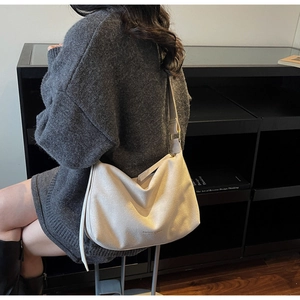 Detailansicht der cremefarbenen Hobo-Tasche mit verstellbarem Gurt und Metallschnalle