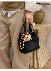 Minimalist black pebble leather bucket bag with cute bear charm and decorative bead chain