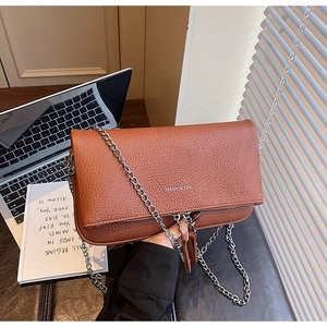 Detail of brown litchi pattern leather bag with silver chain strap and logo lettering