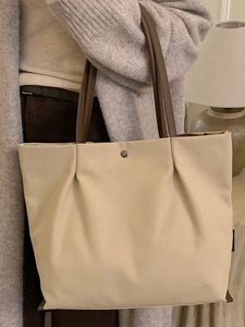Elegant beige minimalist tote bag with deep brown handles and metallic snap detail