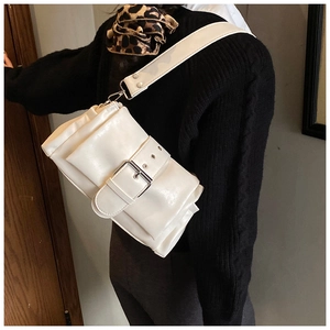 Detail of white leather shoulder bag with oversized buckle on model with leopard scarf