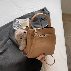 Détail du sac seau en cuir grainé avec fermoir argenté et breloque lapin en peluche