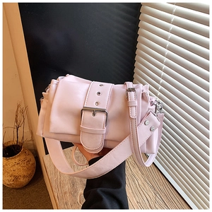 Detail of a light pink leather baguette bag with metal eyelets and wide belt buckle strap