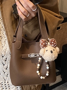 Sac seau en cuir marron foncé avec fermoir argenté et breloque ours en peluche élégant
