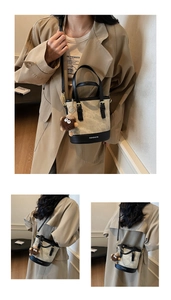 Detail view of stylish color-block bucket bag with beige fabric and black leather trim