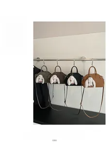 Detail view of four shell-shaped handbags in green, coffee, black and caramel colors