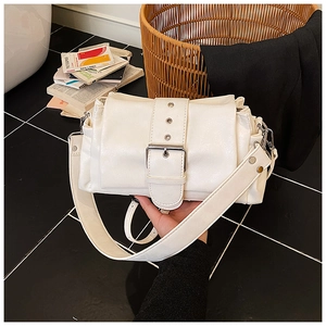 Detail of off-white shoulder bag featuring a large silver buckle and pleated side design