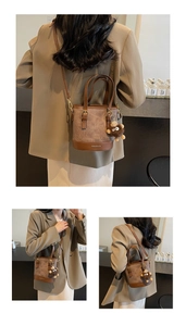 Close-up of brown patchwork bucket bag with plush charm and fashion logo detail