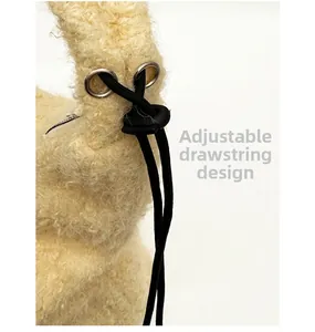 Dettaglio della borsa in peluche gialla con chiusura a coulisse e tracolla regolabile