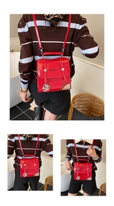 Detail of red leather mini backpack featuring ladybug embroidery and plaid pattern trim
