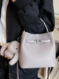 Sac seau minimaliste en cuir grainé gris avec fermoir argenté et charm lapin en peluche