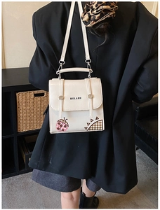 Detailed back view of white square flap bag with ladybug print and fine shoulder strap