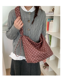 Dettaglio di una borsa hobo marrone a pois con ampi spallacci per un comfort casual