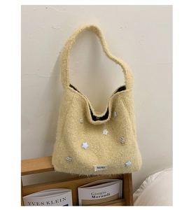 Dettaglio della borsa tote in pile giallo con texture morbida e toppe a stella
