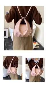 Detail view of the embossed TINCARK logo and flower patchwork on a pink leather backpack