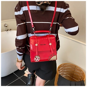 Detail view of red PU leather backpack with cute beetle embroidery and HELAHE logo on the back