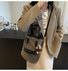 Detail view of bucket bag with FASHION & YM logo and brown plush doll keychain
