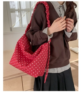 Dettaglio della borsa tote rossa a pois con tracolla arricciata effetto scrunchie