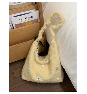 Dettaglio della borsa tote gialla in peluche con stelle e manico morbido arricciato